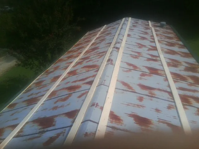 Rusted metal roof panels with new wood purlins before replacement — Storm Damage Roof Repair in Lumpkin by Roofing Brothers