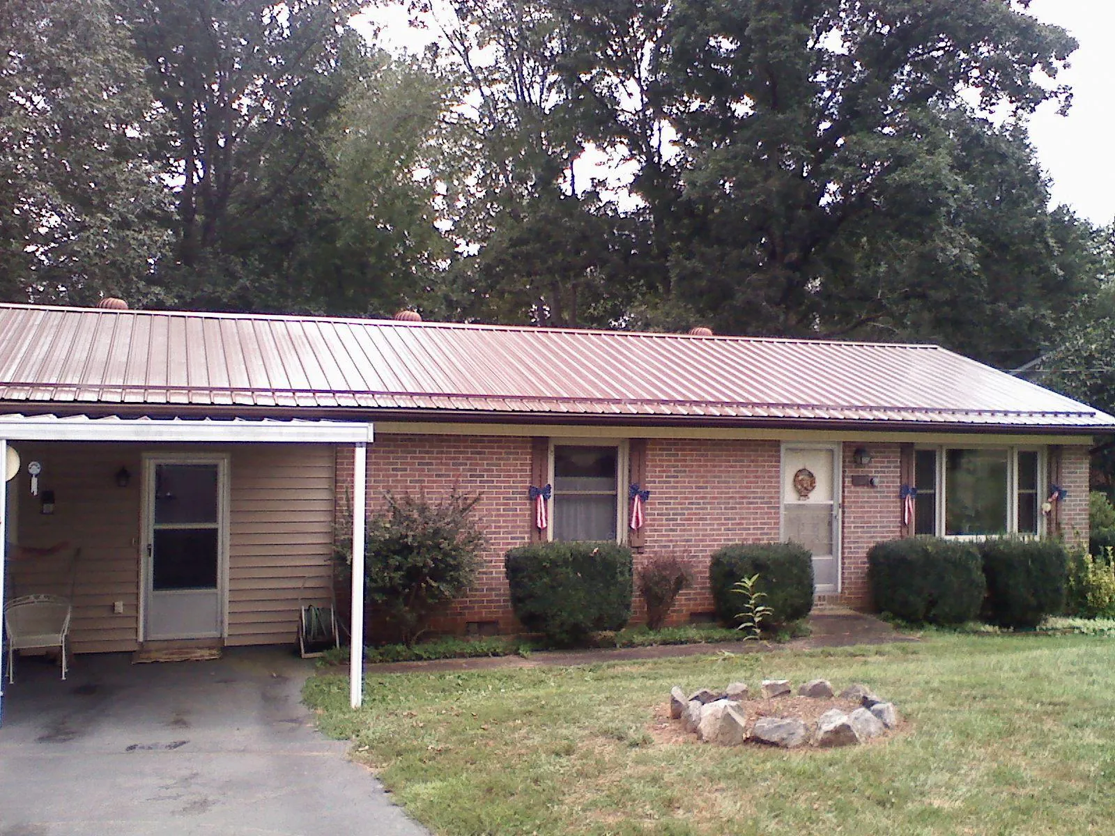 Bronze metal roof and carport on a brick ranch home — Roof Repair work by our crew in Lumpkin